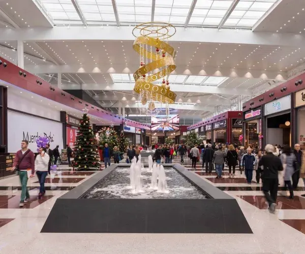Interior promenade fountain under a gold spiral chandelier
