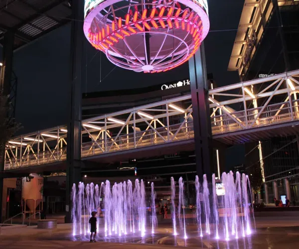 Purple-lit jets on a fairground promenade at night