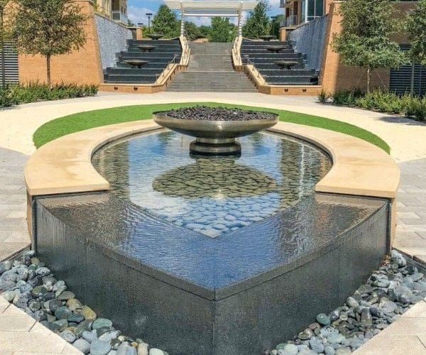 Aerial of a round garden pond ringed by lawn and stepping stones
