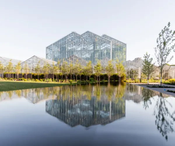 Still reflection pool mirroring a glass conservatory at Frederik Meijer Gardens