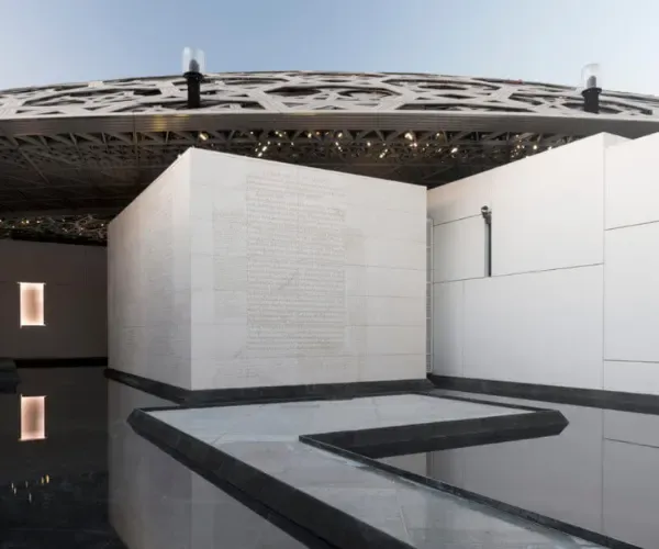 Reflection pool beneath the latticed dome of the Louvre Abu Dhabi