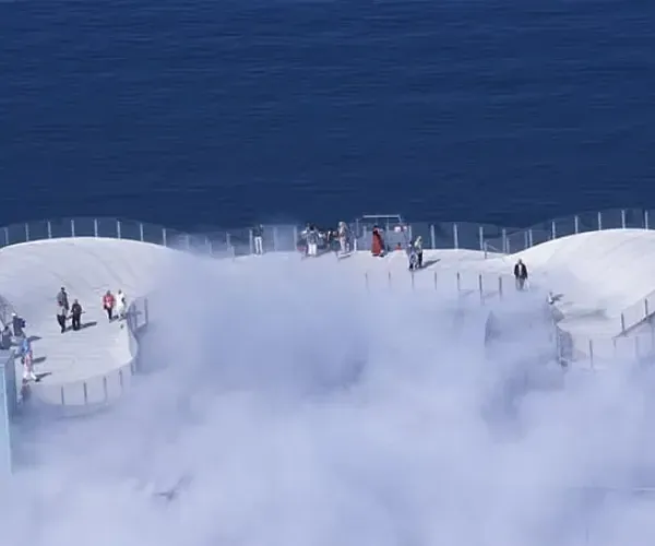 Fog bank drifting across a clifftop observation deck above the sea