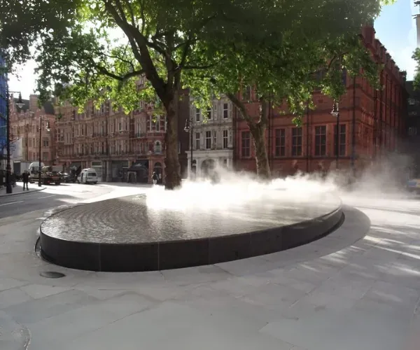 Elliptical black-granite mist basin on a plane-tree-lined city street