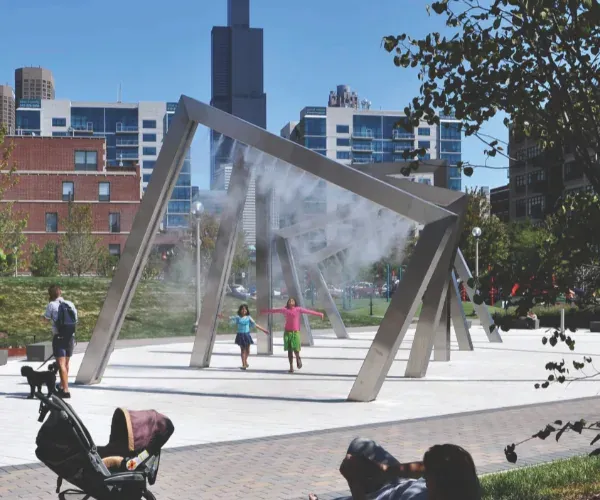 Stainless A-frame misting structure in a downtown park with children running through
