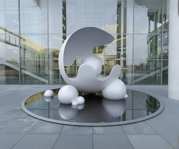 White wave-form sculpture and spheres on a circular reflecting pool