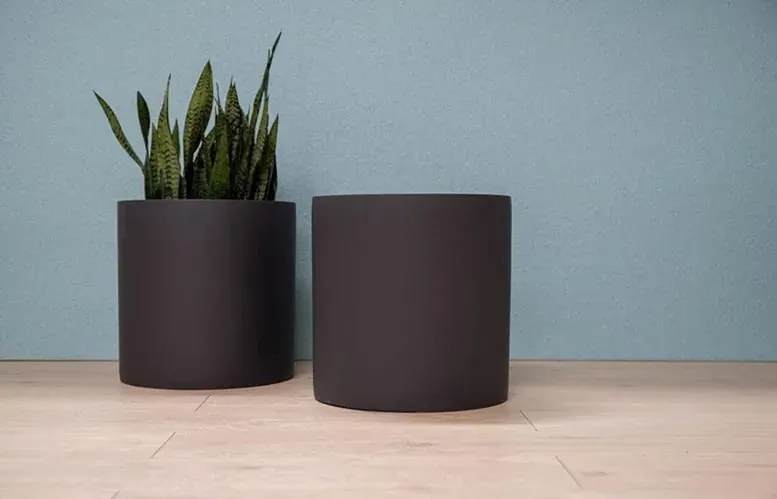 Pair of dark cylindrical planters with sculpted profiles
