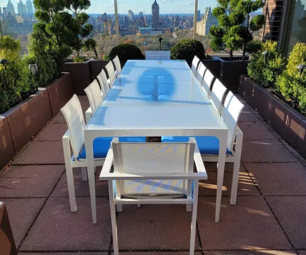 Blue-glass dining table and chairs on a rooftop terrace