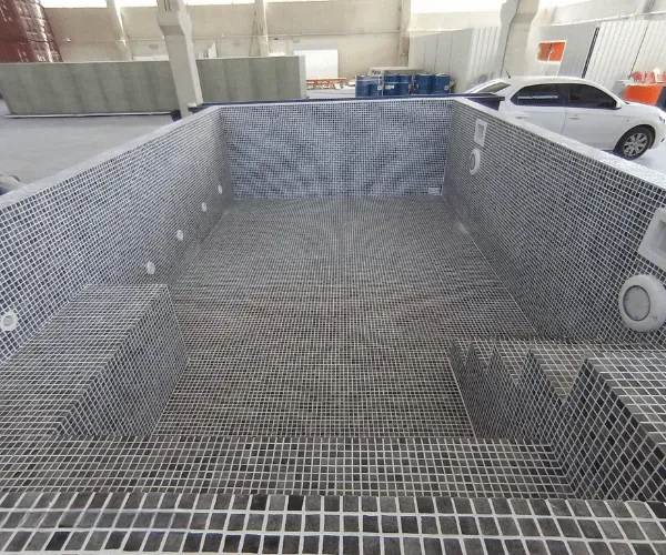 Mosaic-tiled pool shell staged on site before setting