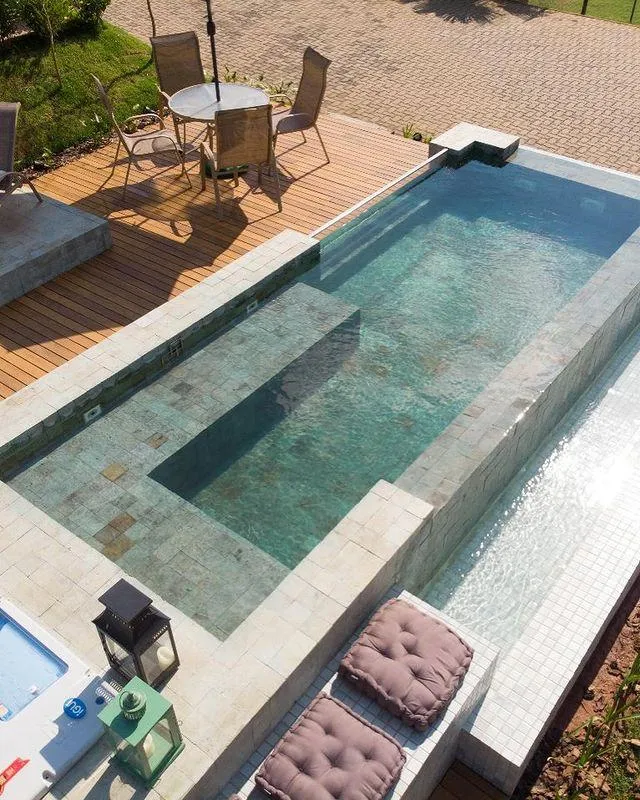Small terrace pool with a partial negative edge and a mosaic step on a stone patio