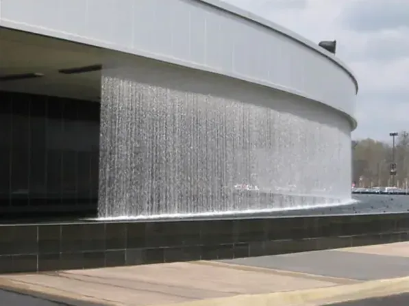 Curved rain curtain over a dark basin