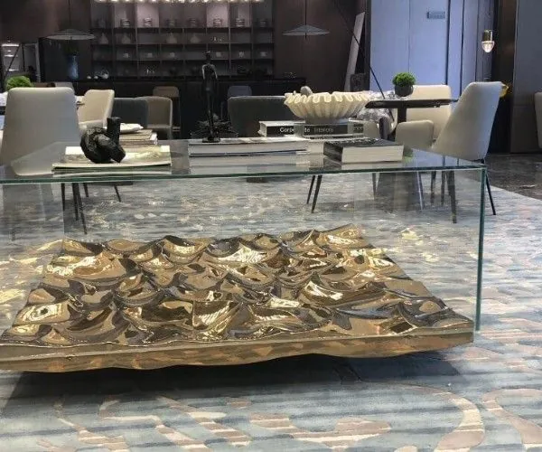 Cast bronze relief table under glass in a showroom