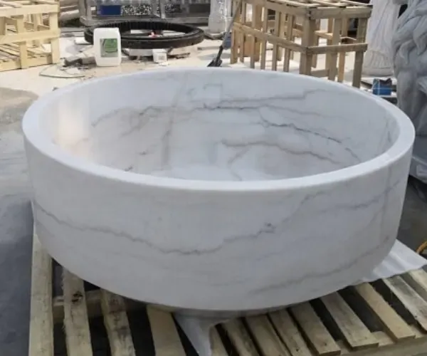 Round white marble basin on a fabrication pallet