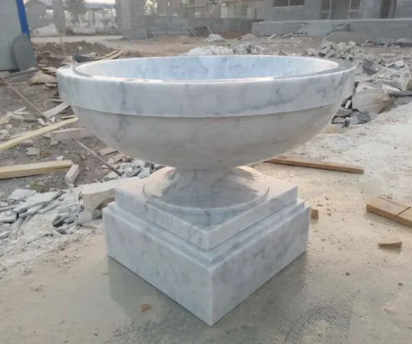 Carved white marble urn on a pedestal in the carving yard