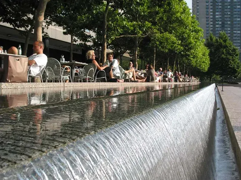 Weir-edge waterfall feature beside cafe seating at the World Financial Center