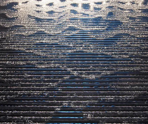 Water running over horizontally grooved dark stone