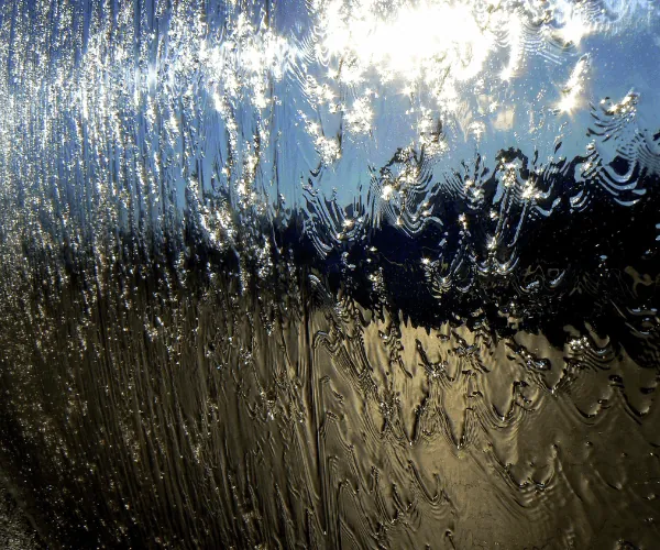 Sunlit water over mirror-polished stainless steel